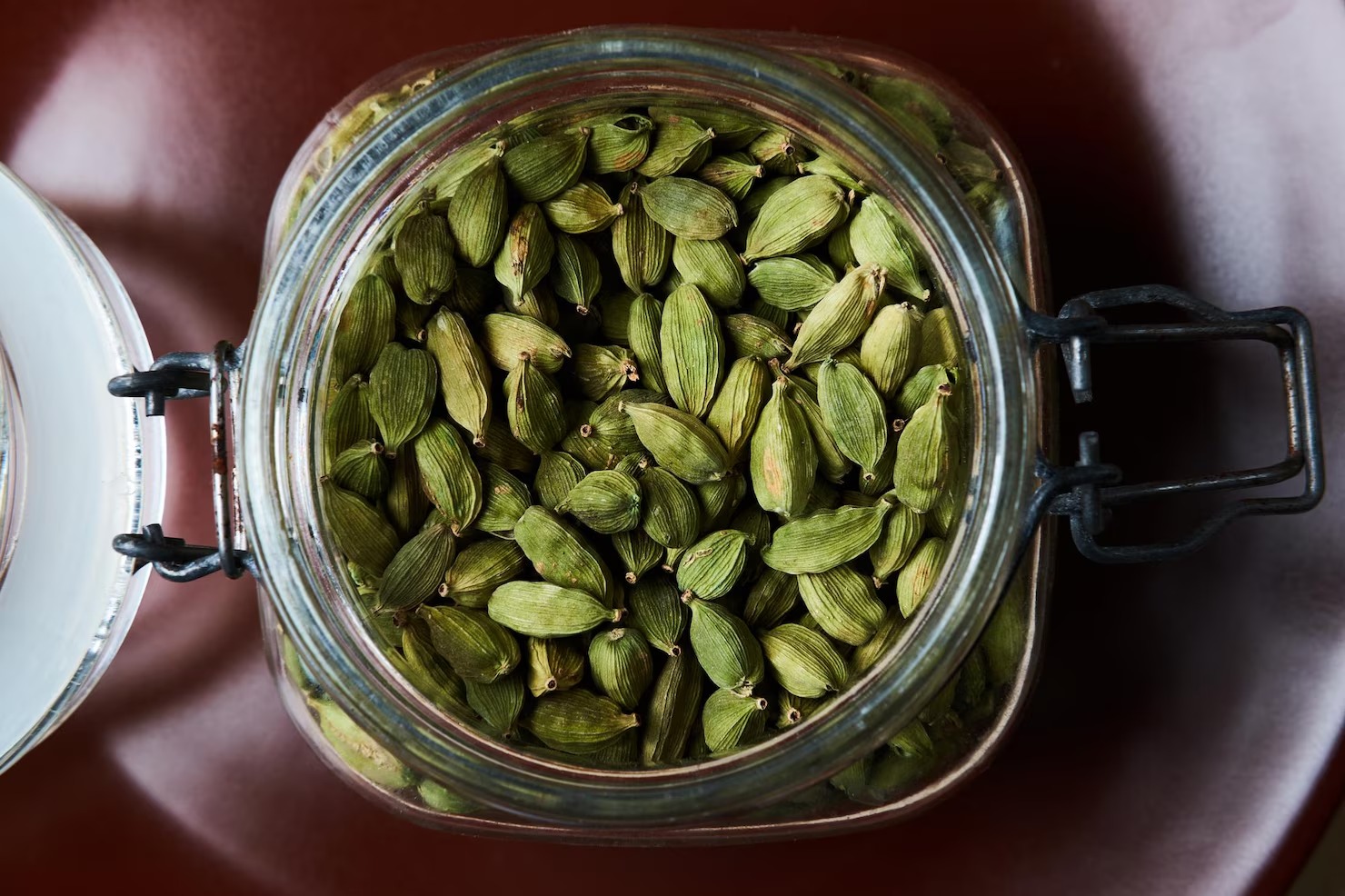 imgi_165_closeup-proto-glass-jar-full-green-cardamom-pods-brown-plate-top-view_613910-21738