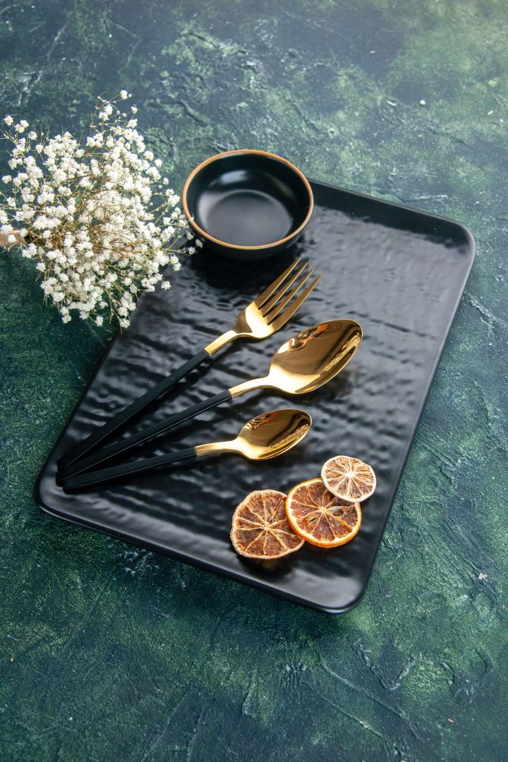 front-view-black-plate-with-golden-cutlery-dark-background (1)